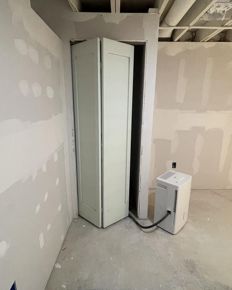 Bi-fold closet doors installed in a drywalled basement