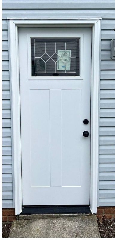 New white entry door hung plumb with black hardware