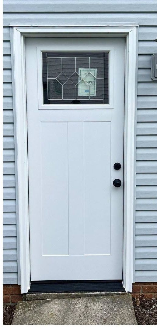 New white entry door with decorative glass, hung and cased