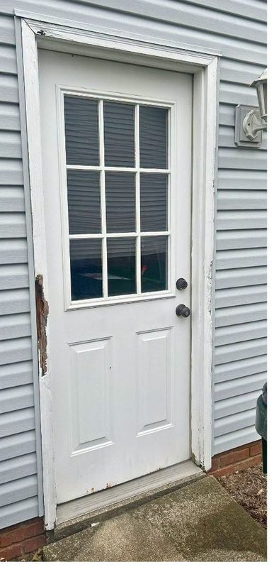 Old entry door with damaged jamb before replacement