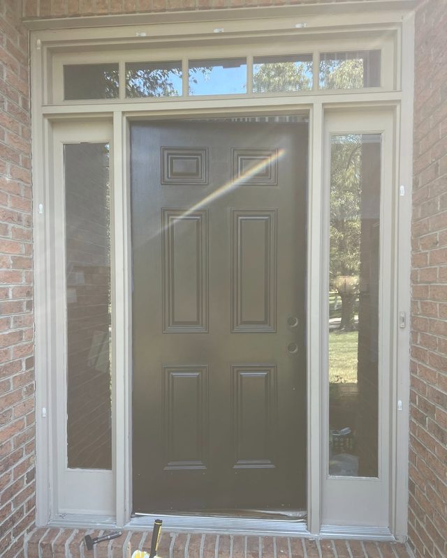 Freshly painted front door between two sidelights