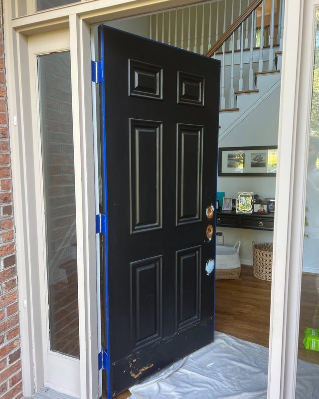 Front door taped off with hardware removed during painting prep