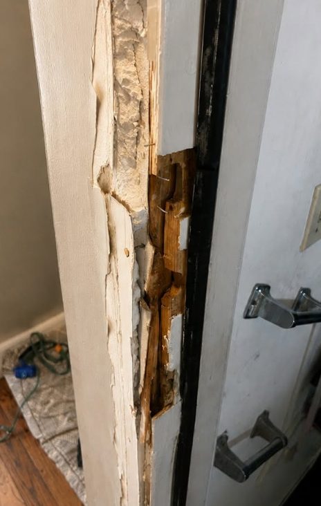 Damaged door jamb with a split hinge mortise before repair