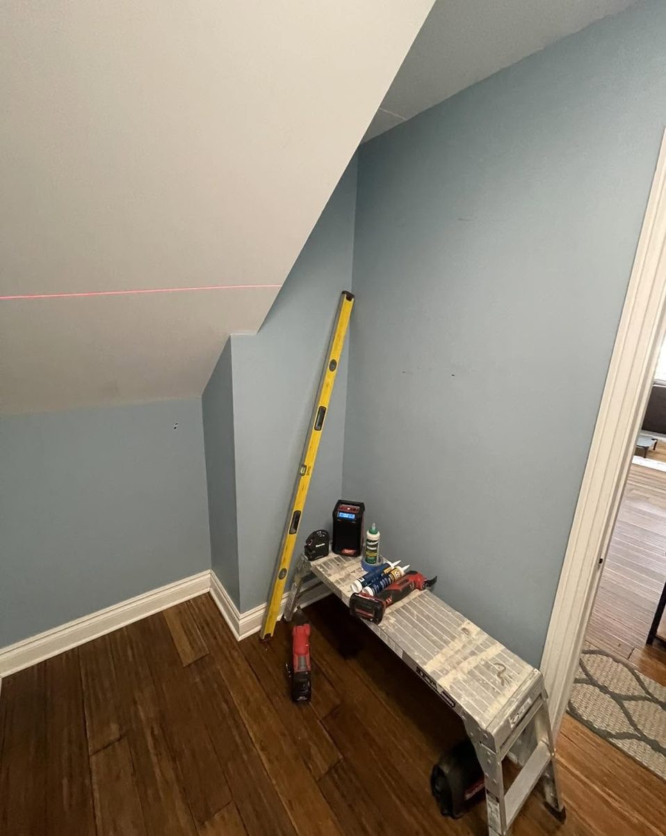 Laser level line marked across a knee wall under a staircase