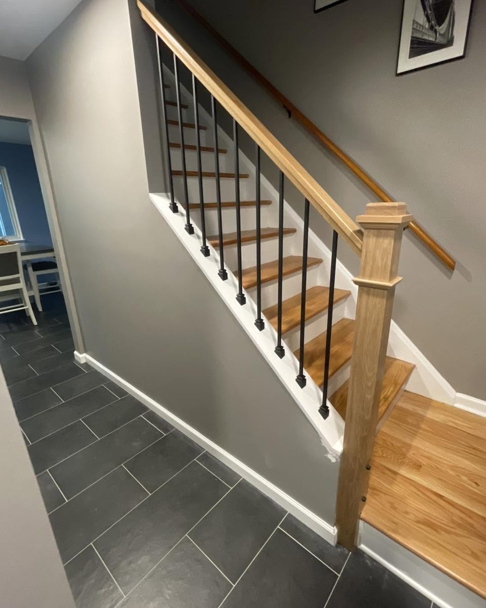Oak stair treads with black iron balusters and an oak handrail