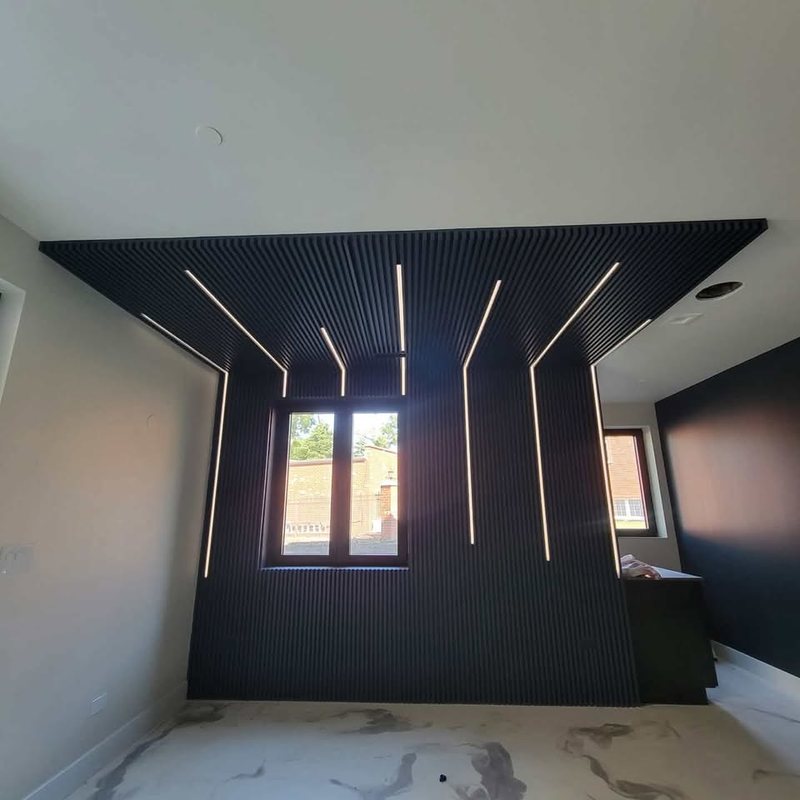 Black slatted feature wall and matching slatted ceiling panel with recessed light strips, wrapping a window