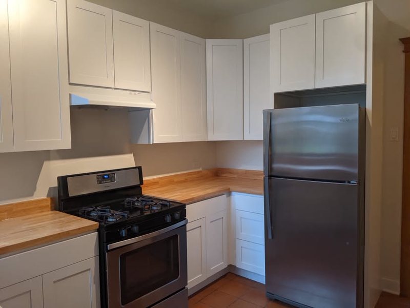 White shaker wall cabinets over butcher block countertops
